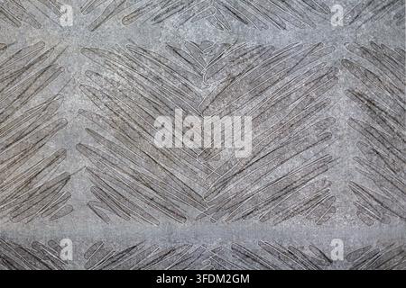 Gray Geometric Chevron Pattern Texture. Gray textured geometric surface with layered diagonal lines forming repeating chevron patterns and weathered Stock Photo
