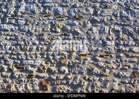 Old stone house wall revealing texture through sidelighting - Ligueil, Indre-et-Loire (37), France. Stock Photo