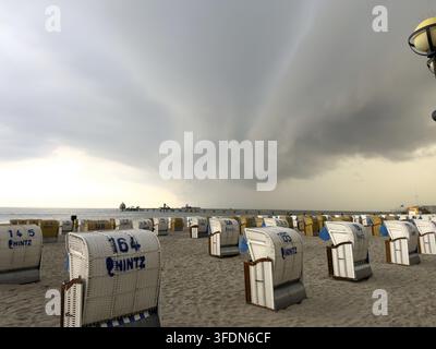 Baltic Sea weather shows all facets: dark clouds, rain, thunderstorms, storms and rainbows over Groemitz beach chairs in Schleswig-Holstein, Baltic Se Stock Photo