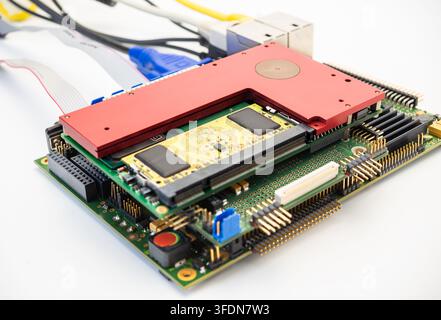 A circuit board shows electronic components and connectors. Cables are attached to the board, ready for use. Stock Photo