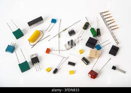 Various types of electronic parts are scattered on a white surface. Stock Photo