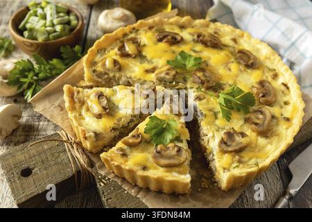 Delicious homemade mushroom quiche with mushrooms and green beans on rustic table Stock Photo