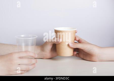 Hands choose eco-friendly paper cup and refuse plastic cup Stock Photo