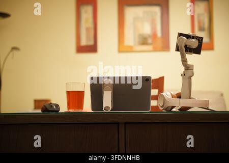 Vintage radio receiver on wooden table beside beer glass and small mouse, with robotic arm in warm indoor scene, framed pictures, soft wall light and Stock Photo