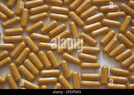 Minimal top-down flatlay with bright curcumin capsules scattered on white marble, highlighting vibrant wellness aesthetics and clean modern style Stock Photo