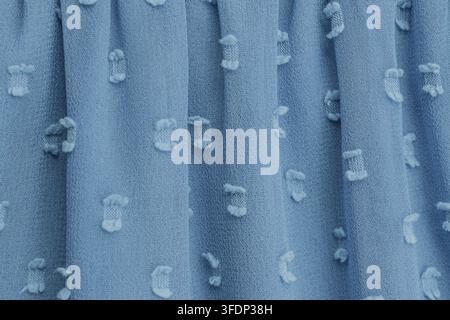 Close-up of light blue chiffon fabric with detailed floral embroidery. Soft folds and translucent layers create an elegant, airy texture with intricat Stock Photo