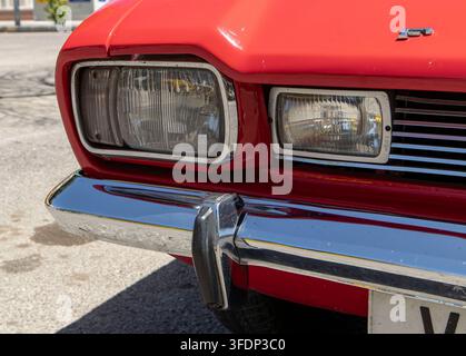 Tavernes Blanques, Spain - June 14, 2026.The photo shows a close-up of the front passenger side corner of a red Ford Capri. The focus is on the dual r Stock Photo