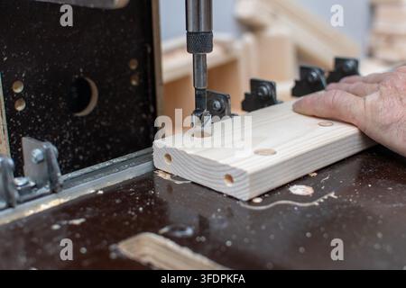Drilling precise holes in wooden workpiece close up Stock Photo