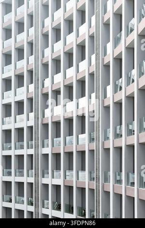Close-up view of a modern apartment building facade featuring repeating glass balconies and vertical grid lines. The image emphasizes rhythm, symmetry Stock Photo