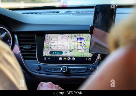 Iserlohn, Germany - August 13, 2026: Car interior with navigation system displaying a map to Witten and smartphone mounted on dashboard. Stock Photo