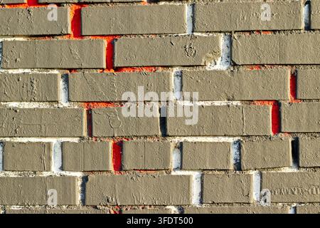 Plastered brick wall pattern with red gaps Stock Photo