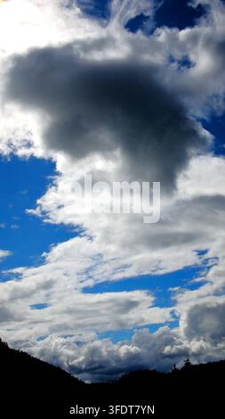 Cumulus cloud formation set against vibrant blue sky. Stock Photo
