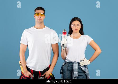 Ready For Renovation. Confident Couple Of Repair Workers Holding Construction Dryer Stock Photo