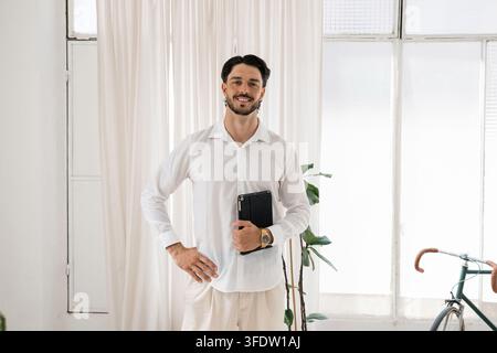 Young professional man smiling holding digital tablet Stock Photo