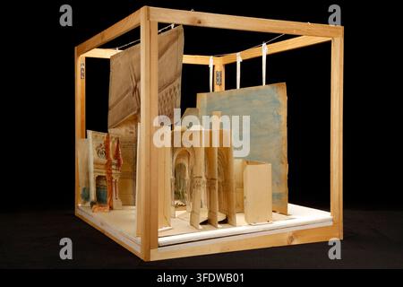 A three-dimensional model of architectural structures made from painted and unpainted cardboard pieces, arranged inside a wooden cube frame, created by Eugène Carpezat, a French designer, in 1885, as part of a set titled "Le Cid: maquette construite de l'acte I, tableau 2". Stock Photo