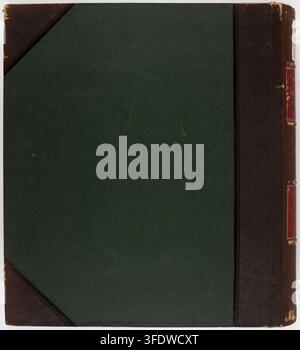 A closed book with a dark green textured cover and dark brown leather corners and spine, featuring two red rectangular labels with gold detailing, by Étienne Moreau-Nélaton, a French photographer, between 1907 and 1912, as part of a collection documenting the architectural heritage of the Aisne department in France. Stock Photo