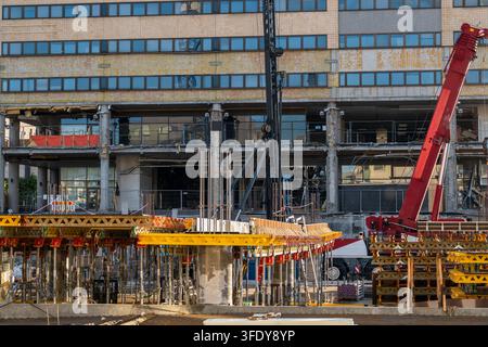 Large building renovation with cranes, formwork and concrete structural work at an urban construction site Stock Photo