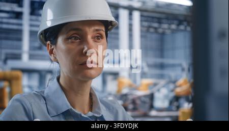 Close Up of Female Technician Controls Modern Software on Desktop Computer Screen in Smart Manufacturing Plant. Cyber Physical Systems and Cloud Servers Drive Efficient Car Assembly Processes. Stock Photo