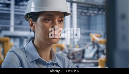 Close Up of Female Technician Controls Modern Software on Desktop Computer Screen in Smart Manufacturing Plant. Cyber Physical Systems and Cloud Servers Drive Efficient Car Assembly Processes. Stock Photo