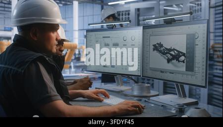 Engineers Collaboratively Program, Monitor Robotic Production Equipment, Entering Commands, Reviewing Operating Parameters to Optimize Automated Manufacturing Workflows in Modern Industrial Facility. Stock Photo