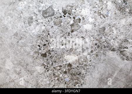 Gray Terrazzo Stone Texture with Embedded Aggregate. Close-up of gray terrazzo stone with embedded mineral chips and mottled surface texture. Stock Photo