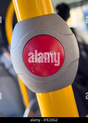 Public transport stop request button with Braille on a yellow handrail. The image represents accessibility, mobility and passenger safety. Stock Photo