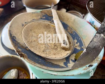 Dust covered dishes and kitchen utensils abandoned inside an old house. The image represents neglect, abandonment and the passage of time Stock Photo