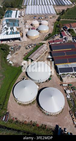 Aerial view of large greenhouses with a circular water tank and solar ...
