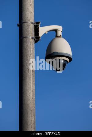 CCTV security dome camera on pole outdoor at blue sky Stock Photo