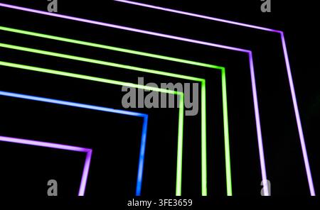 Glowing neon stripped lights on dark background Stock Photo