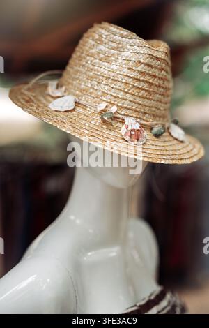 Summer straw hat with seashells on a mannequin puppet Stock Photo