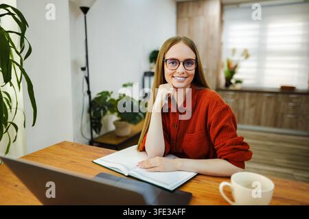 Young woman working remotely from her comfortable home office Stock Photo