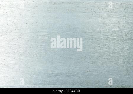 A close-up of a light blue brushed metallic surface with subtle horizontal scratches and a textured, matte finish, ideal for industrial or modern abst Stock Photo