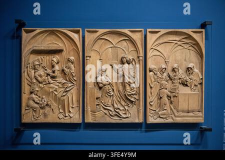Freiburg, Germany - 20 Sep 25: Three carved medieval relief panels showing religious scenes on a blue display wall at Freiburg Minster in Germany. Stock Photo