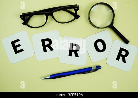 ERROR alphabet letters with magnifying glass, eye glasses and pen on yellow background Stock Photo