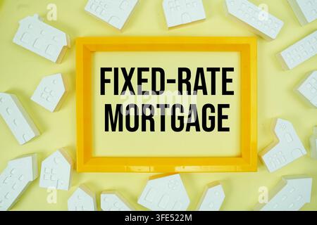 Fixed-Rate Mortgage text with house models on yellow background Stock Photo