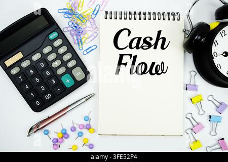 Cash Flow text written on notepad with calculator and alarm clock Stock Photo