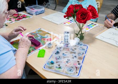 AN ELDERLY FEMALE RESIDENT ENGAGING IN A CREATIVE EMBROIDERY CLASS IN AN ASSISTED LIVING FACILITY, BRISBANE, QUEENSLAND, AUSTRALIA. Stock Photo