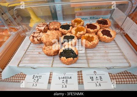 Assorted Korean scones and pastries displayed in a bakery in Korea with price tags in Korean won. Stock Photo