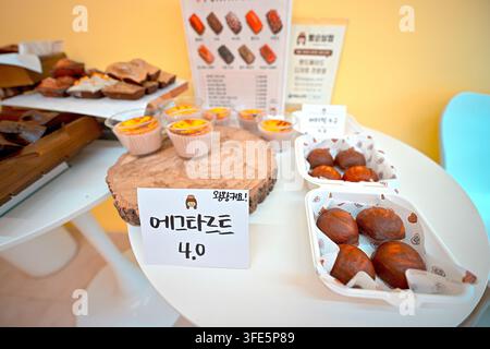 Assorted Korean bakery items including egg tarts and bread displayed on a table in Korea. Stock Photo