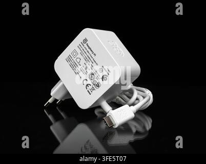 Genuine white Raspberry Pi 27W 5.1V 5A EU plug charger with USB-C connector isolated on dark reflective surface Stock Photo