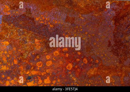Abstract background image featuring a close-up of heavily rusted metal. Rich oxidized colors and rough texture create an organic, weathered appearance Stock Photo