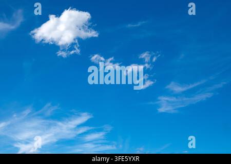 Sky background with fluffy white clouds on a bright blue sky Stock Photo