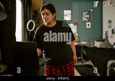 Biracial Woman Working on Laptop at Home for Remote Job Stock Photo