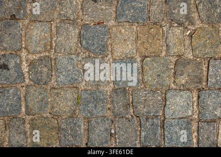 Natural cobblestone pavement made of square stone blocks. Urban paving texture represents traditional masonry, construction and a durable street surface Stock Photo