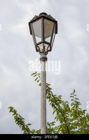 A dirty street lamp against a cloudy sky Stock Photo