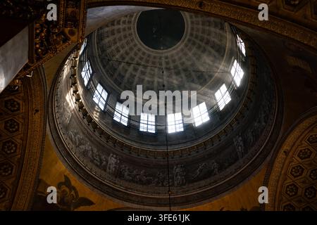Low angle view of the majestic coffered dome inside Kazan Cathedral in Saint Petersburg, Russia, with gilded ornaments and sunlight streaming through Stock Photo