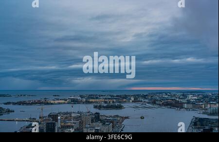 Aerial view of Helsinki harbor and cityscape under a dramatic cloudy sky during spring in Helsinki, Uusimaa, Finland. Stock Photo