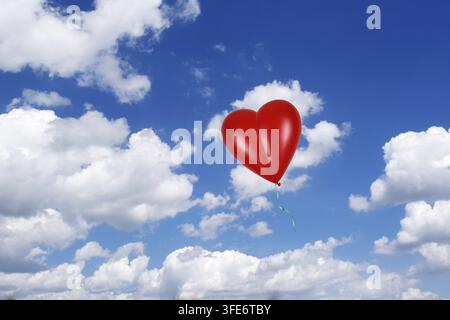 Red heart balloon against blue sky, heart shape, balloon, cumulus clouds, studio, Lower Saxony, Federal Republic of Germany Stock Photo