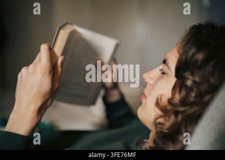 Close-up shot of young man reading book at home Stock Photo